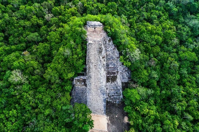 Aerial view of the Cobá Nohoch Mul pyramid rising above the jungle canopy